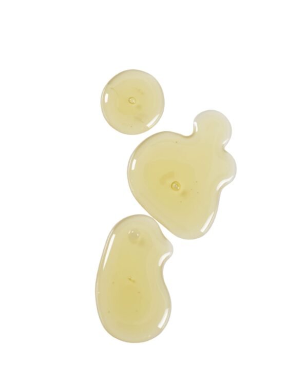 Golden liquid body oil swatch drops showing lightweight product texture.