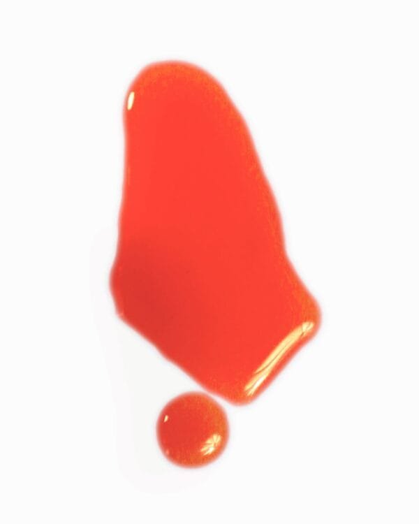 Vibrant orange liquid texture swatch and droplet of Fade Face Oil serum