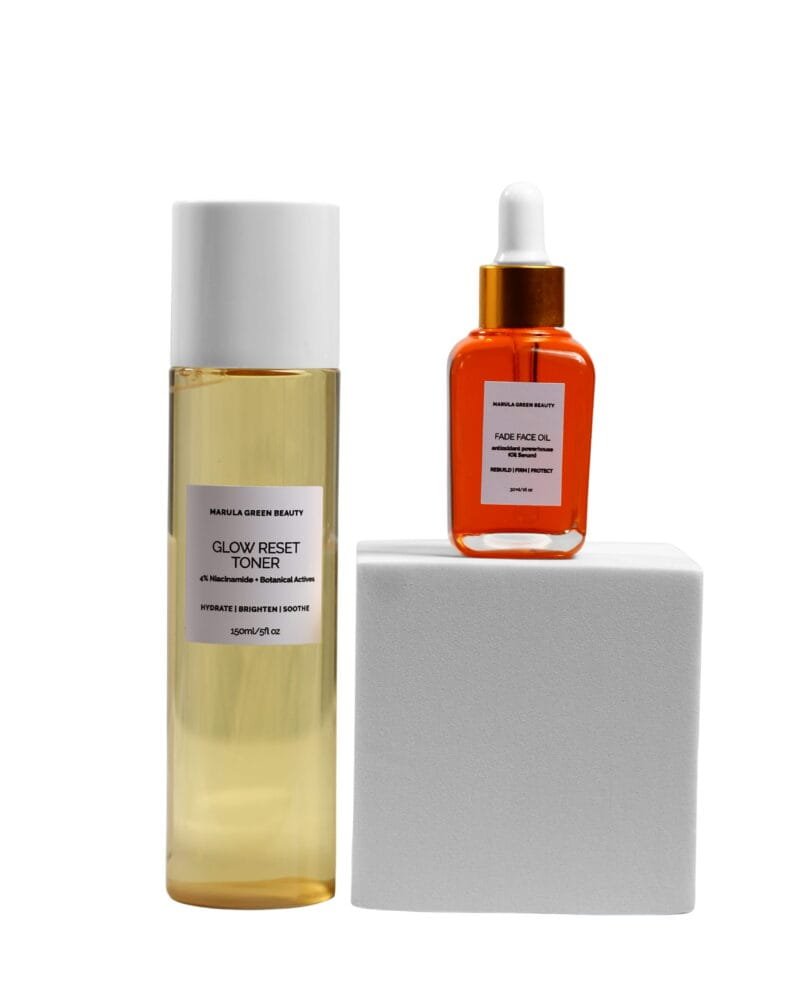 Marula Green Beauty Glow Reset Toner and Fade Face Oil displayed together in an elevated product arrangement, with the toner standing beside a white pedestal and the orange-tinted face oil positioned on top, against a clean white background.