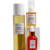 A layered product display of Marula Green Beauty skincare featuring Complexion Tonic Serum stacked high on a central white pedestal with Fade Face Oil and Glow Reset Toner placed around it.