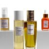 Marula Green Beauty The Complete Ritual set — Complexion Tonic Serum (30ml) and Fade Face Oil (30ml) raised on white pedestals, framing the Glow Reset Toner (150ml) and Essence of Harmony Body Oil (100ml) at centre, against a white background.